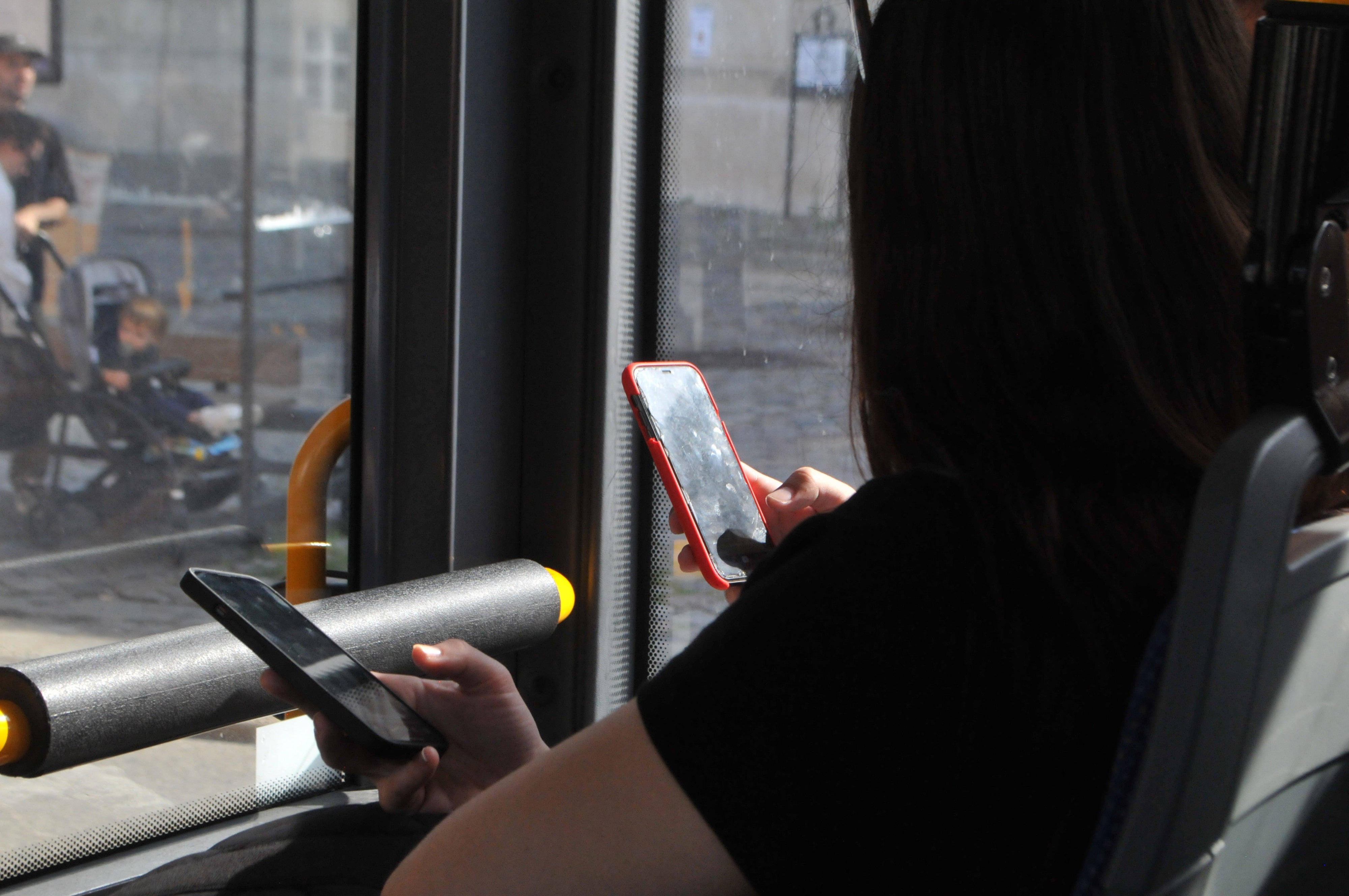 People using their cellphones while in transit, September 2023.