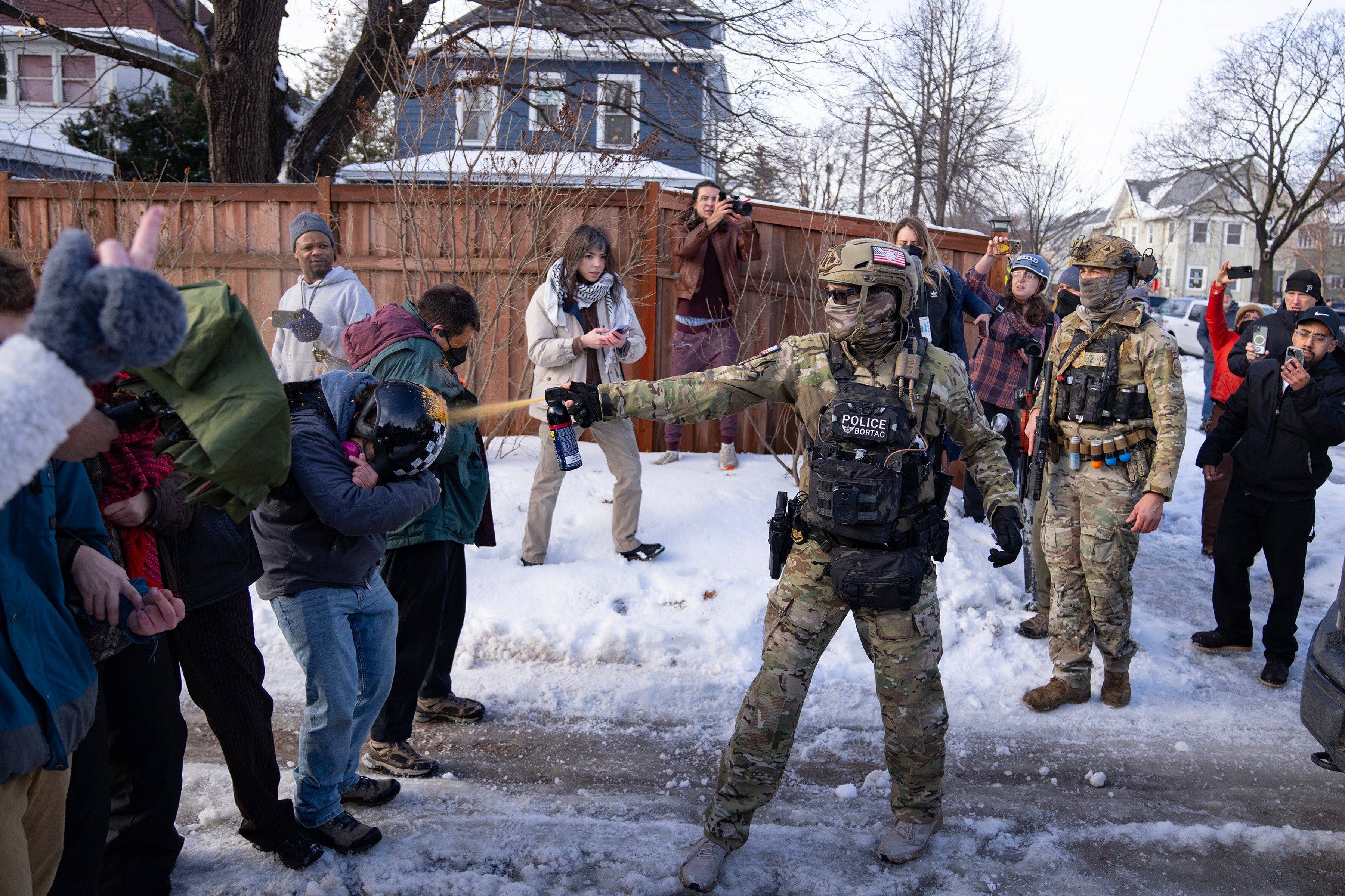 A US Border Patrol Tactical Unit agent sprays pepper spray into the face of a protestor near the scene where a woman was shot and killed by a federal agent, in Minneapolis, Minnesota, January 7, 2026.
