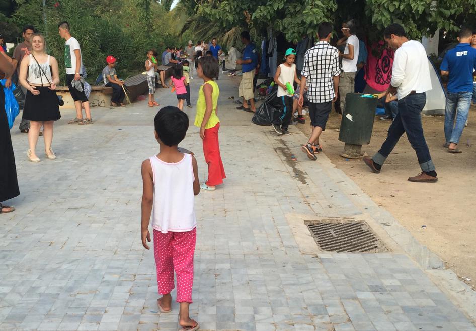 Афганские дети играют с волонтером в палаточном лагере в афинском парке Педион ту Ареос. В начале недели правительство обнародовало планы переселения людей из парка в лагерь, который оно собирается оборудовать.