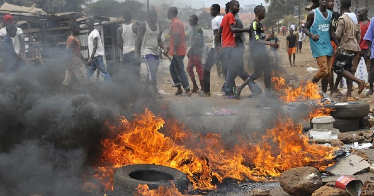 Tires burn during a clash on April 13, 2015 in the capital, Conakry, between policemen and Guinean opposition supporters.  The protesters clashed with security forces over a dispute with the government over the timing of both local and presidential electi