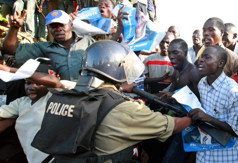 A Ugandan riot policeman uses his weapon to push back protesting supporters of opposition Forum for Democratic Change (FDC) leader Kizza Besigye in Kampala, Uganda, February 20, 2006.