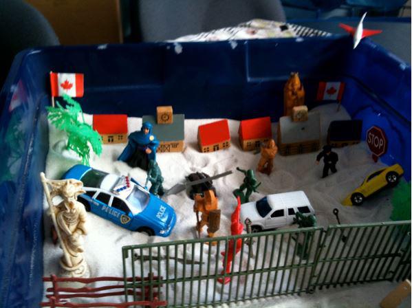 Dominated by symbols of violence, security, and barricades, this sand tray was created by a 12-year-old boy who had been held in a Canadian immigration detention facility for seven months with his mother and older sister. He appeared to have developed mul