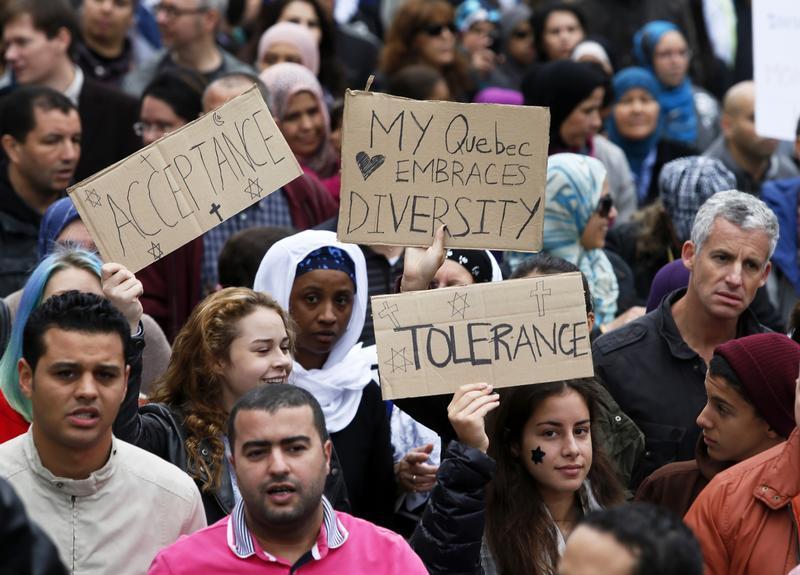 Demonstrators hold signs as they protest against Quebec's proposed Charter of Values in Montreal, September 14, 2013.