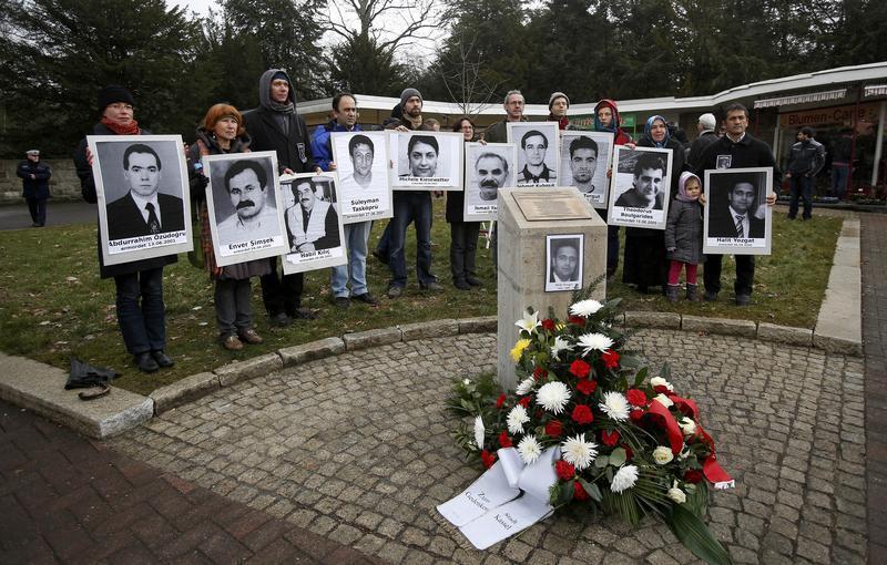 People hold pictures of the victims of the National Socialist Underground (NSU) group at the memorial to Halit Yozgat in Kassel, April 6, 2013.
