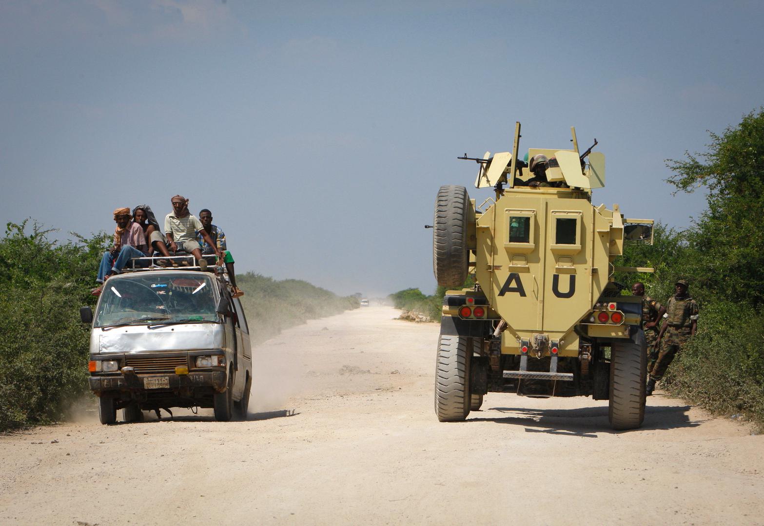 A commuter taxi drives past an African Union Mission in Somalia (AMISOM) armoured vehicle, December 2010 