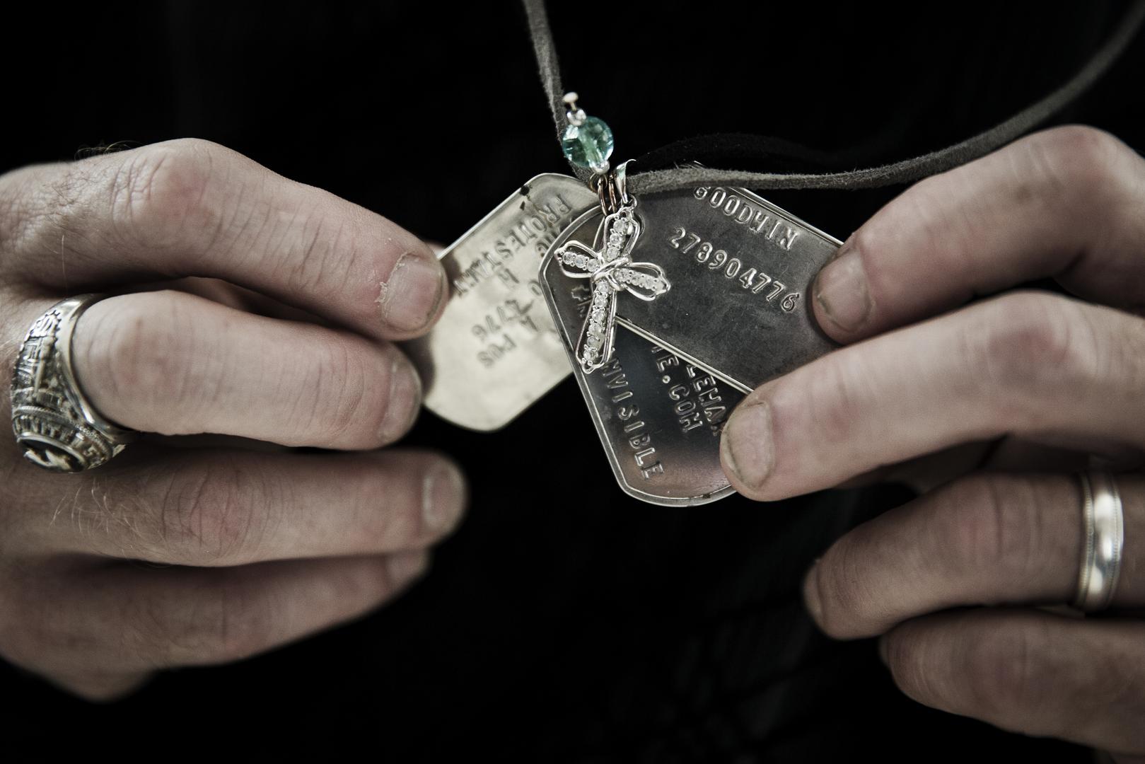 Gary Noling holding dogtags belonging to his daughter, Carri Goodwin, a rape victim who died of acute alcohol intoxication less than a week after receiving an Other Than Honorable discharge from the Marines.