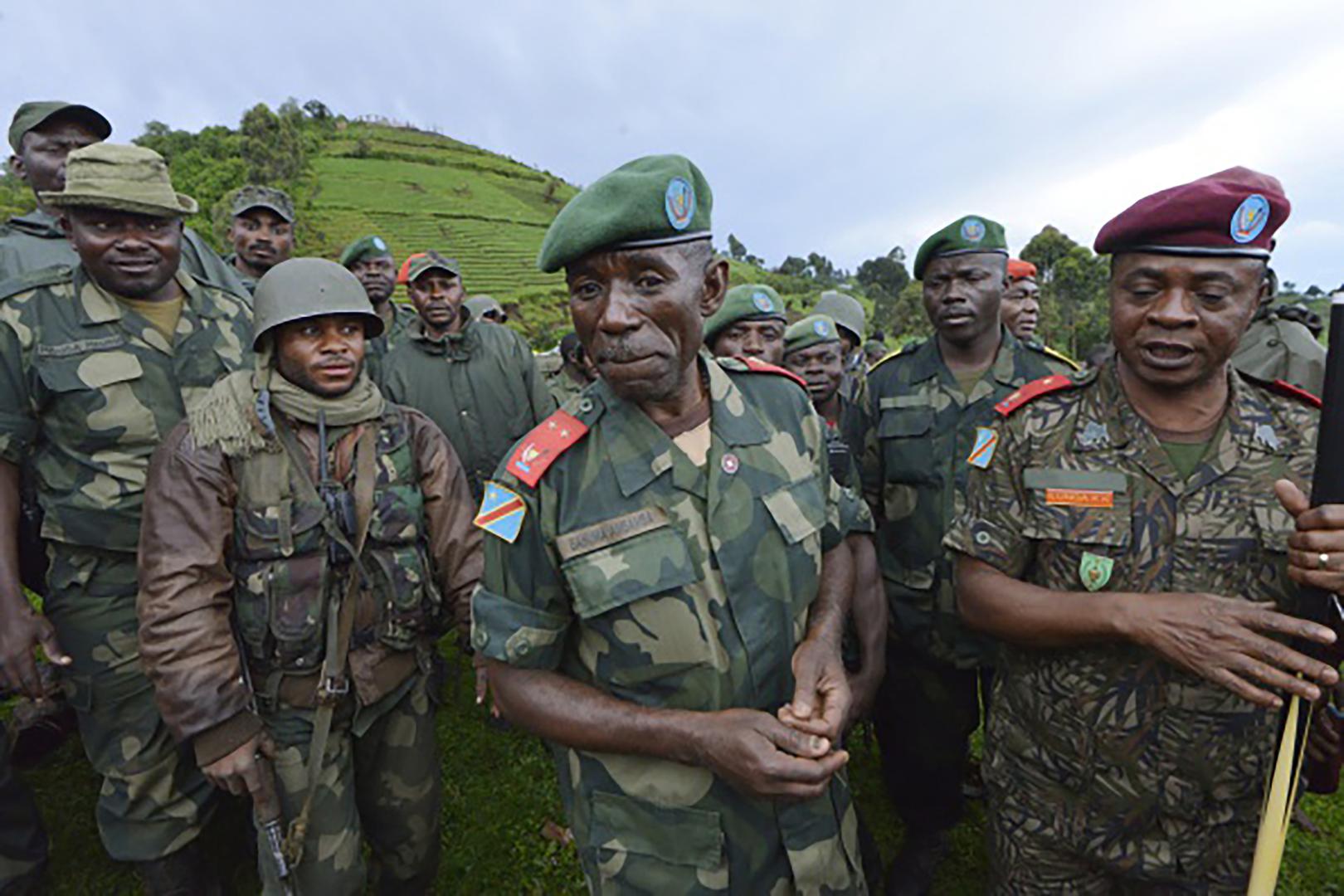 General Ilunga Kampete (right) speaks with General Bahuma Ambamba (center) near Chanzu, eastern Democratic Republic of Congo, on November 5, 2013.