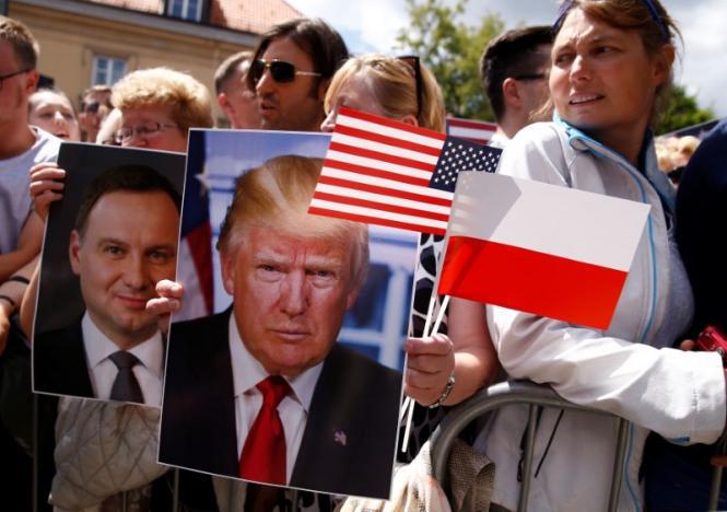 People holding portraits of U.S. President Donald Trump and Polish President Andrzej Duda wait for U.S. President Donald Trump's public speech at Krasinski Square, in Warsaw, Poland July 6, 2017. REUTERS/Kacper Pempel