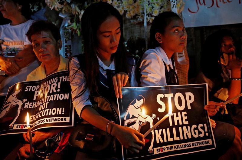 Protesters and residents hold lighted candles and placards at the wake of Kian Loyd delos Santos, a 17-year-old high school student, who was among the people shot dead last week in an escalation of President Rodrigo Duterte's war on drugs in Caloocan city