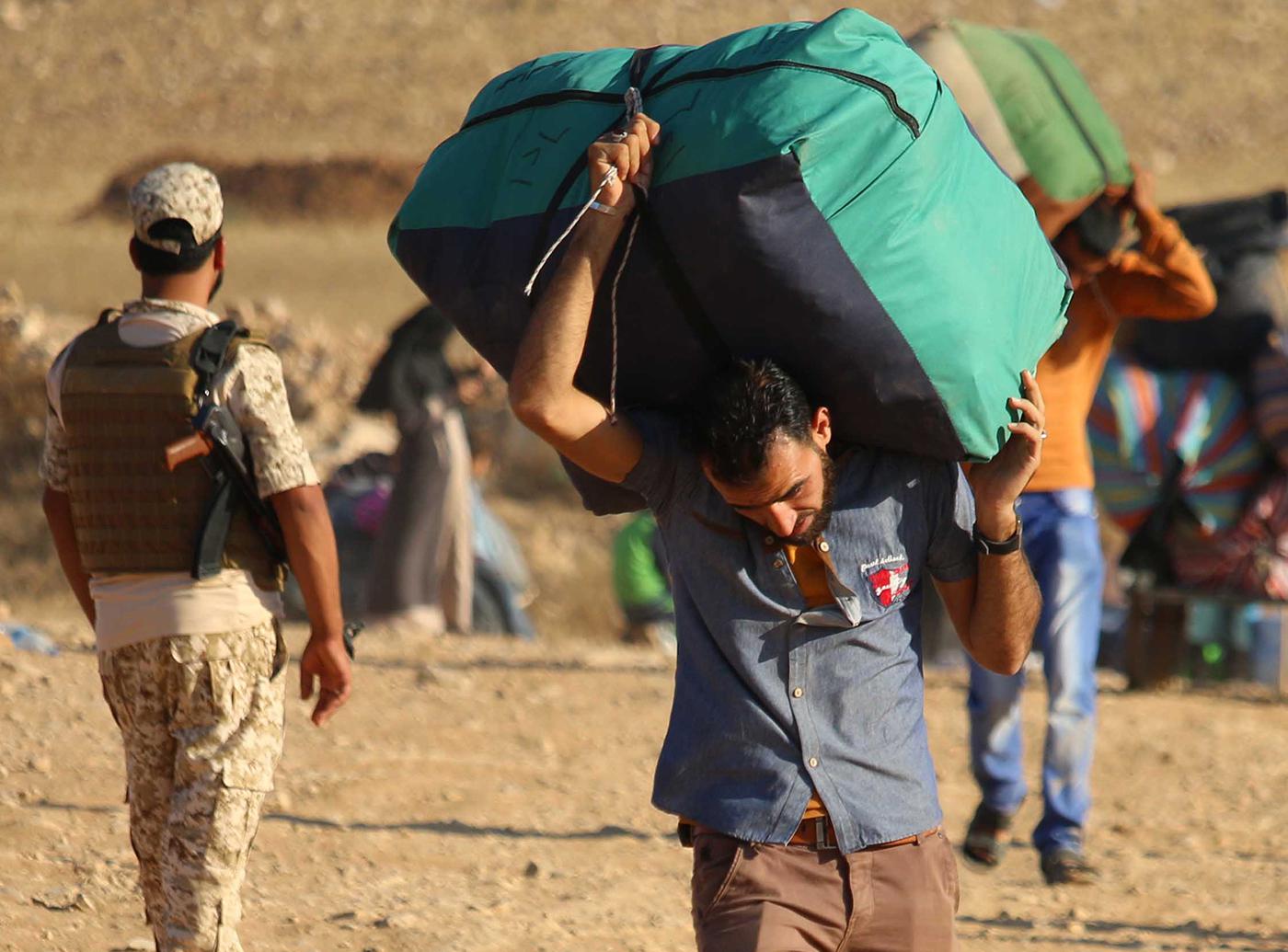 Syrian refugees carry belongings as they return to Syria after crossing the Jordanian border near the town of Nasib, in the southern province of Daraa, on August 29, 2017.  © 2017 Mohamad Abazeed, AFP, Getty Images