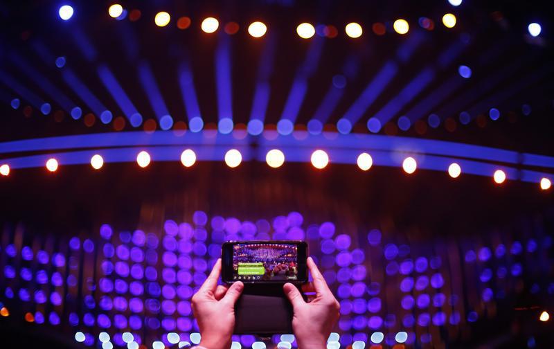 A spectator takes a photo on a mobile phone before the Semi-Final 2 for Eurovision Song Contest 2018 at the Altice Arena hall in Lisbon, Portugal.