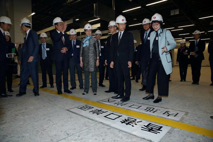 Hong Kong Chief Executive Carrie Lam and other officials stand in front of a line dividing Hong Kong and mainland Chinese control zone as part of the joint immigration checkpoint inside West Kowloon Terminus