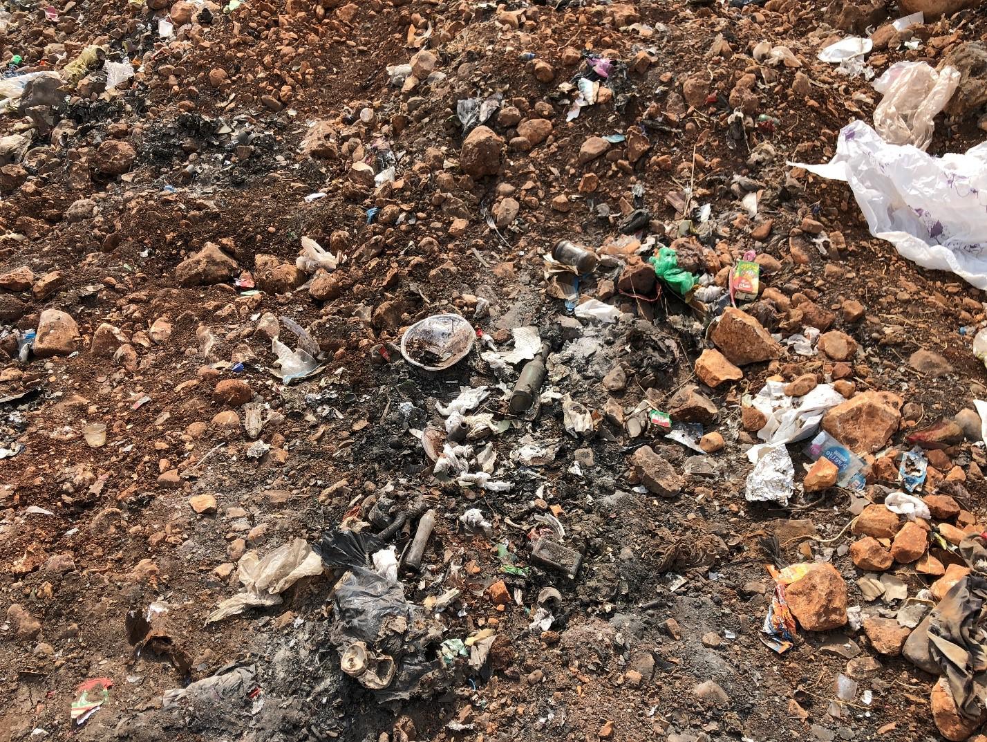 Signs of burning at the al-Qantara dump, including soot from recent burns and ash deposits. 