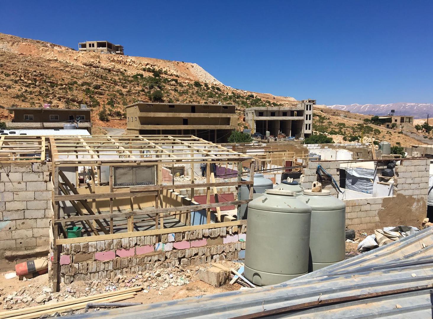 Reconstruction of a dismantled shelter begins in a Syrian refugee camp in Arsal, Lebanon.