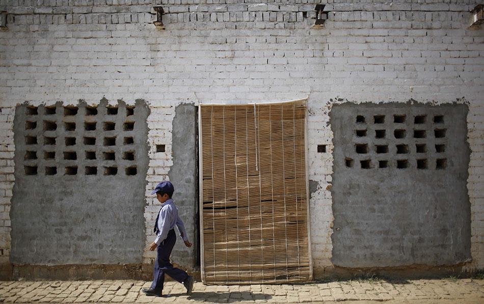 A boy passes by a classroom in a school in Qutbal, Pakistan.