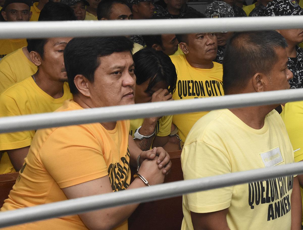 Andal Ampatuan Jr., left, a former town mayor who oversaw and led the Maguindanao Massacre, waits with co-accused at a court inside a prison facility at Camp Bagong Diwa, Taguig city, Metro Manila, Philippines