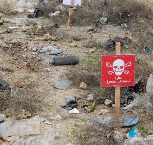 Une sous-munition de fragmentation 9N24 non explosée est visible sur un terrain près de l'école Abdo Salama à Sarmin, dans le gouvernorat d'Idlib en Syrie, suite à une attaque menée le 1er janvier 2020. Des démineurs ont pose deux écriteaux rouges près de