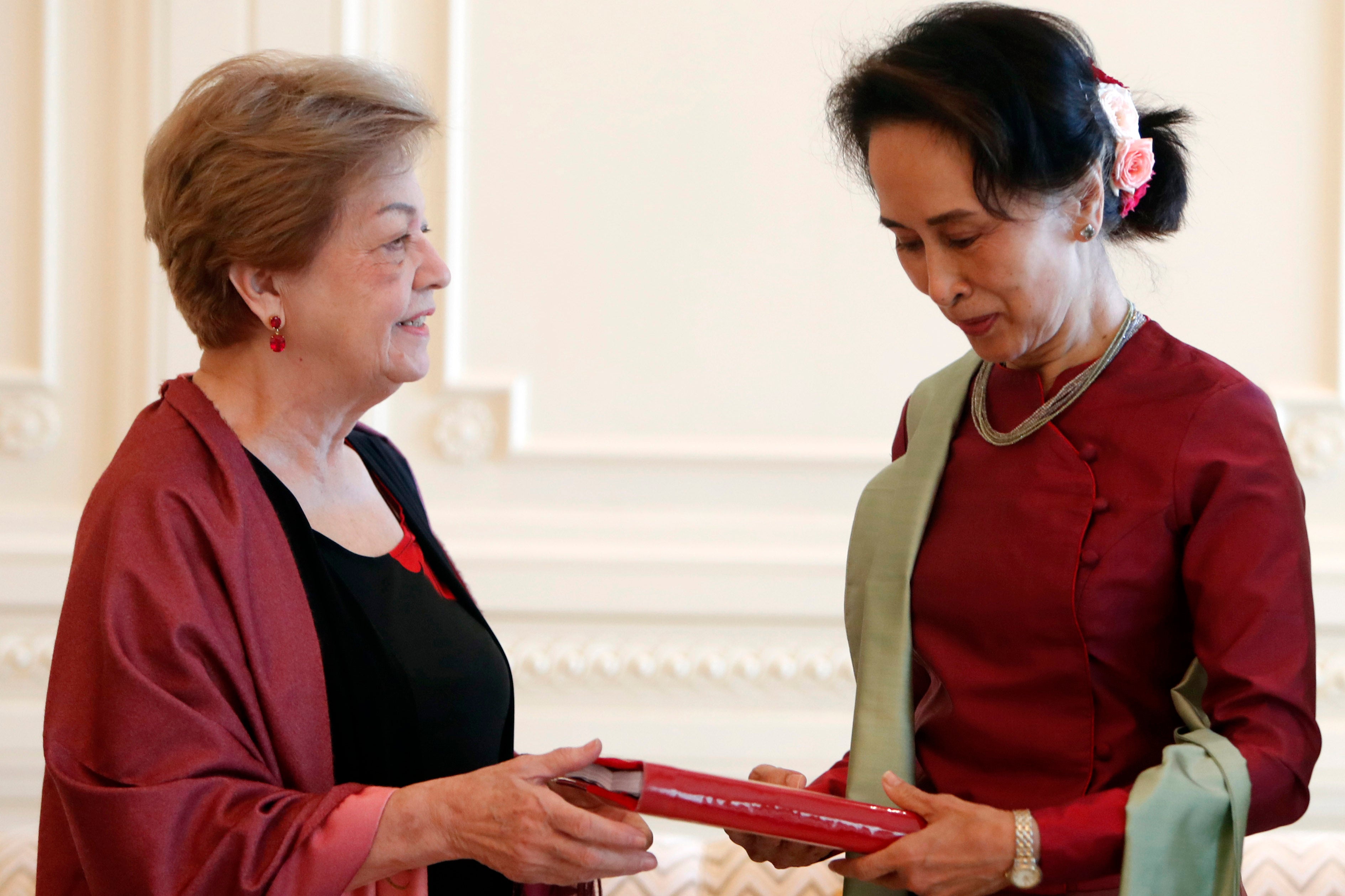 Myanmar's leader Aung San Suu Kyi, right, receives a final report from Philippine diplomat Rosario Manalo, a member of the Independent Commission of Enquiry for Rakhine State, at the Presidential Palace in Naypyitaw, Myanmar, Monday, Jan. 20, 2020. 