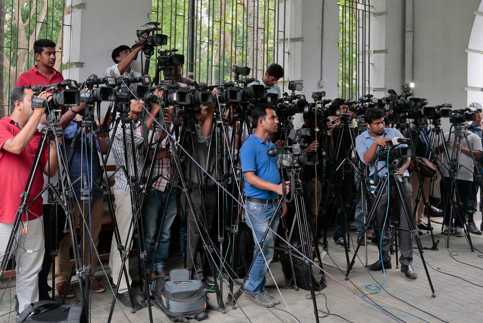 In this May 3, 2016 file photo, Bangladeshi journalists cover proceedings outside a court in Dhaka, Bangladesh. 