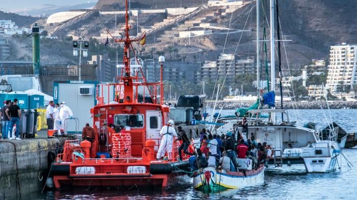 Men disembark from a wooden boat at the Arguineguín pier, on Gran Canaria, one of Spain’s Canary Islands, after a dangerous journey in the Atlantic Ocean.