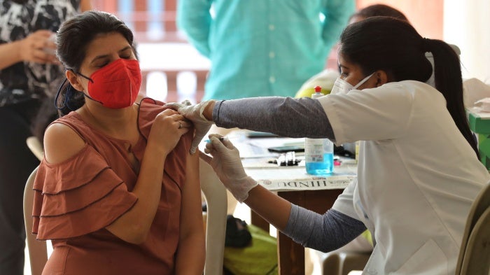 A woman receives the AstraZeneca vaccine for Covid-19 at an apartment building in Bengaluru, India, April 24, 2021.