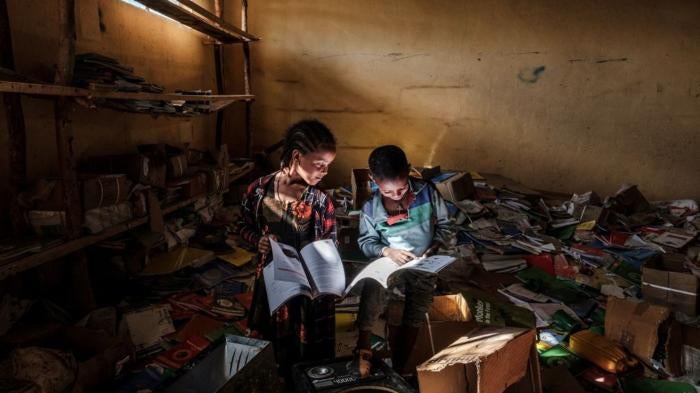 Children look at books in an elementary school in the village of Bisober, Tigray on December 9, 2020. The school was occupied by Tigray Special Forces and also damaged after fighting broke out between Ethiopian and Tigray forces in November 2020.
