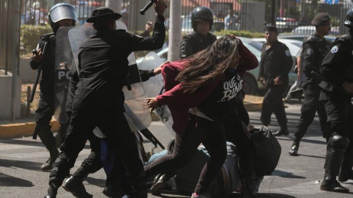 National police officers beat opposition member Valeska Valle and other demonstrators taking part in a "National sit-in" protest against President Daniel Ortega's government in Managua on March 30, 2019.