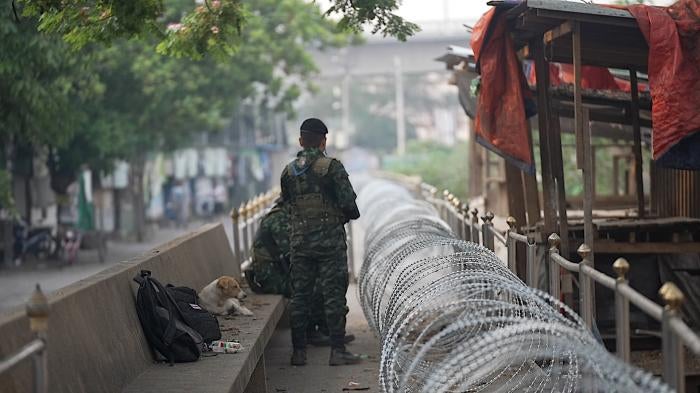 Soldiers standing next to barbed wire