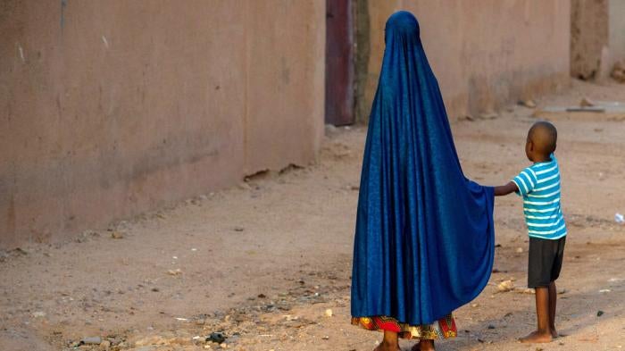 A girl holds the hand of a boy in Agadez, Niger on October 9, 2018.