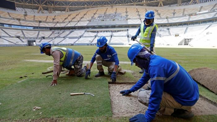  Workers lay the turf inside the Lusail Stadium, the venue for the 2022 Qatar World Cup final, in Lusail, Qatar, November 18, 2021.