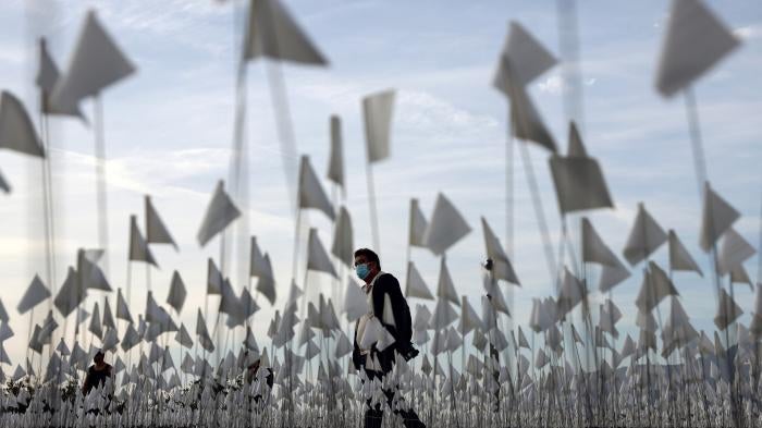 A white flag memorial installation outside Griffith Observatory honoring the nearly 27,000 Los Angeles County residents who had died from COVID-19 .