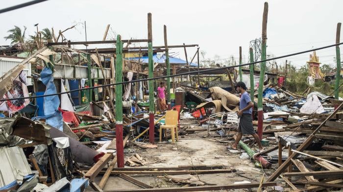  Local residents walk past damaged buildings after Cyclone Mocha in Sittwe township, Rakhine State, Myanmar, May 16, 2023. 