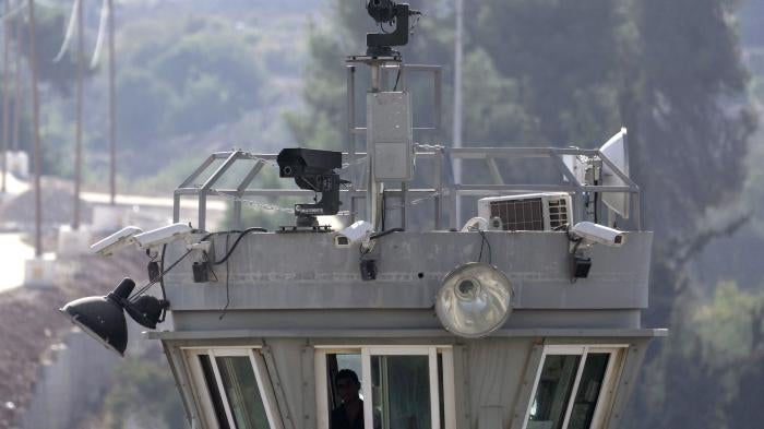 Two guns sit atop a guard tower along with surveillance cameras overlooking the Aroub refugee camp in the Israeli-occupied West Bank, October 6, 2022. 