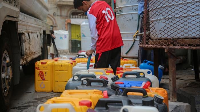 A child fills plastic containers with water