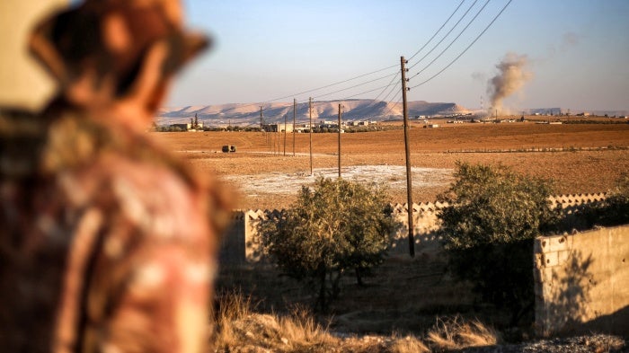 A fighter of the Turkish-backed Syrian National Army faction looks towards a bombardment near the Tishrin Dam in the vicinity of Manbij, in the east of Syria's northern Aleppo province, on January 10, 2025.