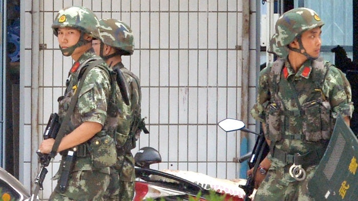 Armed Chinese police officers patrol on the street