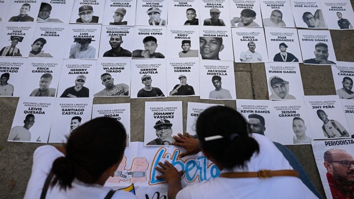 People posting photos of detainees on a wall