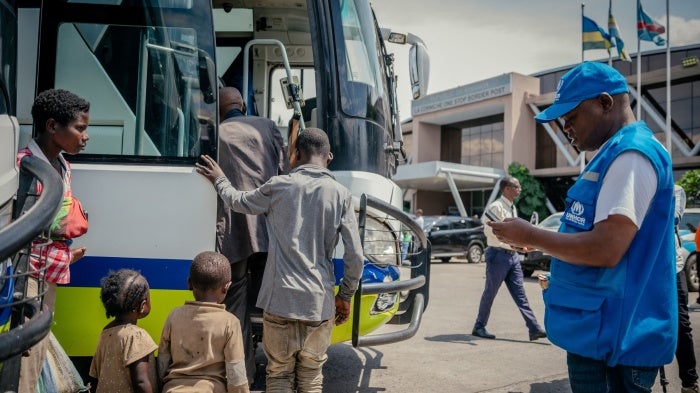 Displaced people board a bus after undergoing checks at the border between the Democratic Republic of Congo and Rwanda