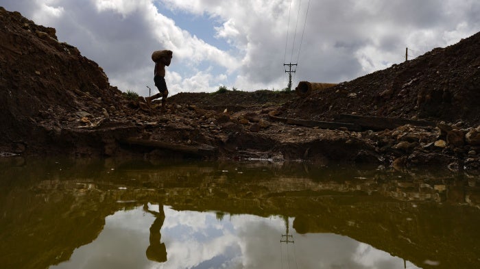 A gold miner carries a sack of rocks to a grinding mill at a mine in El Callao, Bolivar state, Venezuela, April 29, 2023. 