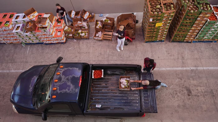 Volunteers help load vehicles during a food distribution at the San Antonio Food Bank for SNAP recipients and other households affected by the US federal shutdown, November 6, 2025. 