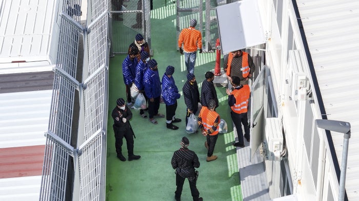 Migrants entering a detention center for processing at the port of Shengjin, northwestern Albania, January 28, 2025.