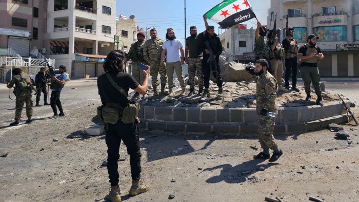 Syria's security forces pose for a picture on a roundabout in the predominantly Druze city of Sweida on July 15, 2025, following clashes between Bedouin communities and Druze fighters. Syrian government forces entered the majority Druze city of Sweida on July 15, 2025, the interior ministry said, aiming to end clashes with Bedouin communities  that have killed nearly 100 people.