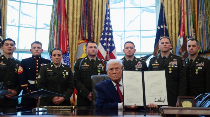 US President Donald Trump shows a signed executive order classifying fentanyl as 'weapon of mass destruction' during a Mexican Border Defense Medal presentation in the Oval Office at the White House in Washington, DC, December 15, 2025.