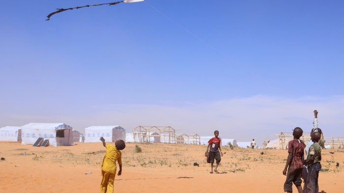 Sudanese refugee children from Darfur fly a handmade kite inside the Touloum refugee camp in Wadi Fira province, eastern Chad, November 30, 2025.