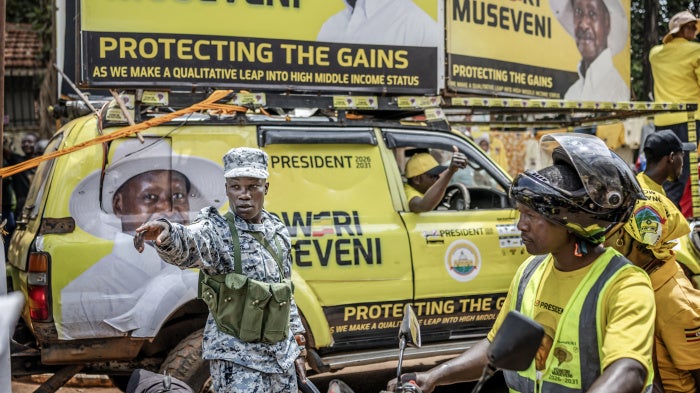 A member of the Ugandan police force gives instructions to supporters of Uganda's incumbent president and National Resistance Movement (NRM) presidential candidate Yoweri Museveni entering the rally grounds ahead of the party's closing campaign rally ahead of the 2026 Ugandan general elections, in Kampala on January 13, 2026.