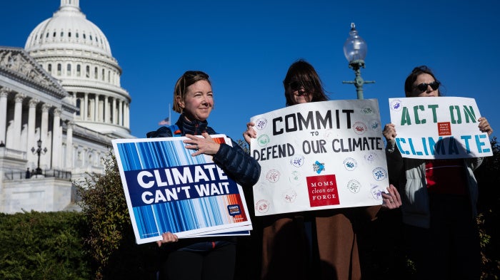 Climate activists hold signs during a press conference outside the US capitol building