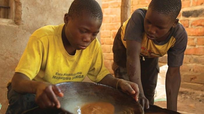 A 15-year-old boy mixes mercury and ground gold ore at a processing site in Mbeya Region, Tanzania. 