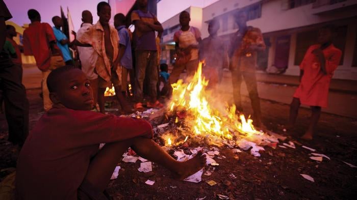 Street children in Mbale town in Uganda, 140 miles east of the capital, Kampala, surround an open fire to stay warm at night.