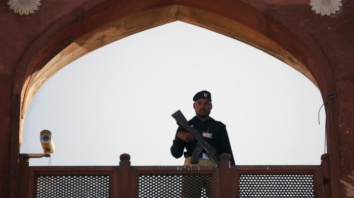 A police officer is framed by the architecture of Lahore's Badshahi Mosque while standing guard during a prayer session on Eid al-Adha November 7, 2011. © 2011 Mohsin Raza/Reuters 