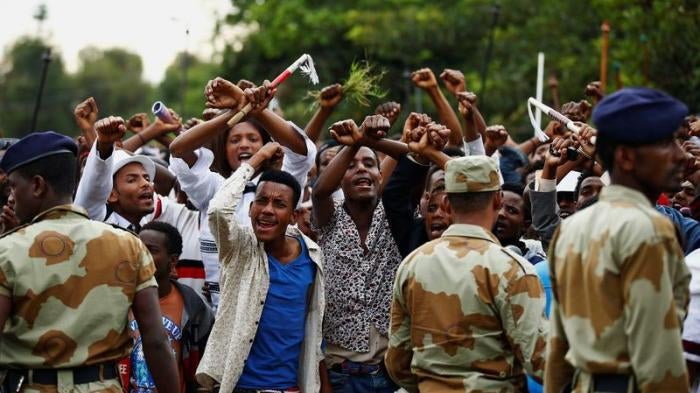 Demonstrators chant slogans while flashing the Oromo protest gesture during Irreecha, the thanksgiving festival of the Oromo people, in Bishoftu town, Oromia region, Ethiopia, October 2, 2016.